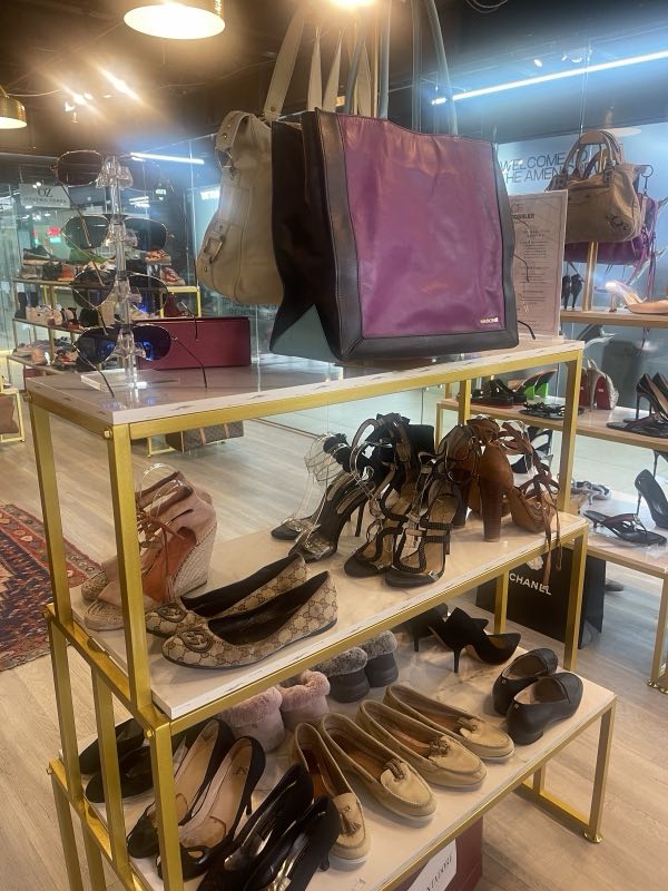 Luxury handbags and designer shoes on gold display shelves